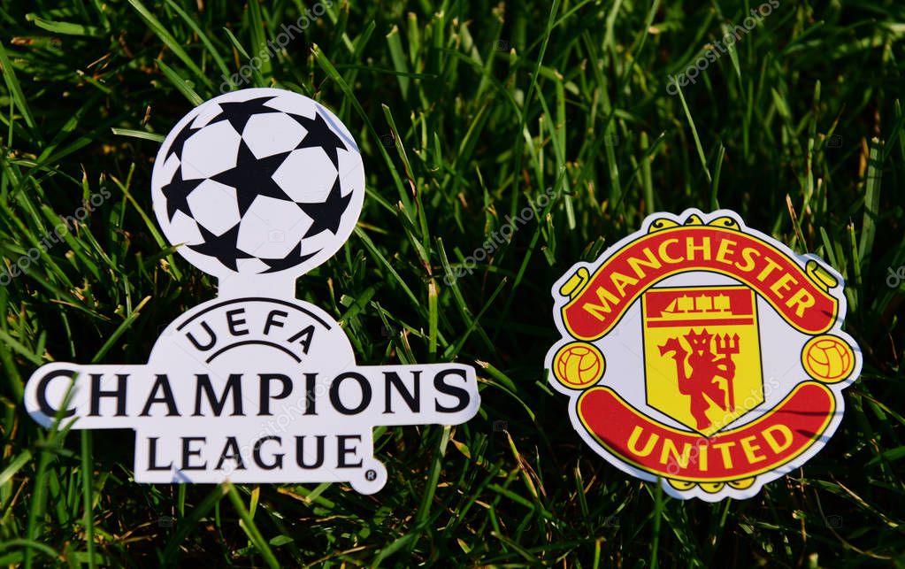 September 6, 2019 Istanbul, Turkey. The emblem of the English football club Manchester United next to the logo of the Champions League on the green grass of the football field.
