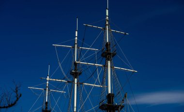 Mavi gökyüzüne karşı yelkensiz bir geminin direkleri