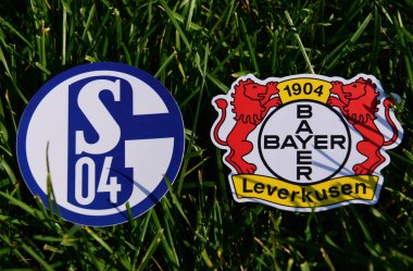 6 Eylül 2019, Münih, Almanya. Yeşil çimlerde Alman futbol kulüpleri Bayer Leverkusen ve Schalke 04 Gelsenkirchen 'in amblemleri