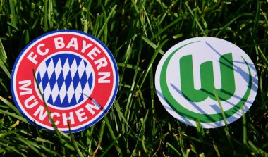 6 Eylül 2019, Münih, Almanya. Yeşil çimlerde Alman futbol kulüpleri Bayern Münih ve Vfl Wolfsburg 'un amblemleri