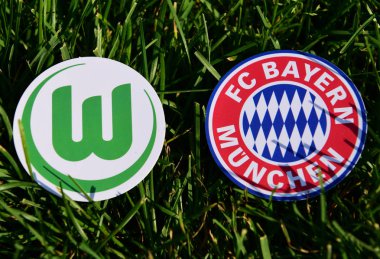 6 Eylül 2019, Münih, Almanya. Yeşil çimlerde Alman futbol kulüpleri Bayern Münih ve Vfl Wolfsburg 'un amblemleri