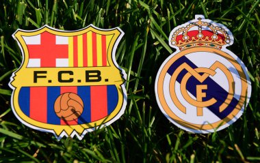 6 Eylül 2019, Madrid, İspanya. İspanyol futbol kulüpleri Barcelona ve Real Madrid 'in amblemleri çimlerin üzerinde.