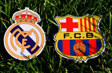 6 Eylül 2019, Madrid, İspanya. İspanyol futbol kulüpleri Barcelona ve Real Madrid 'in amblemleri çimlerin üzerinde.
