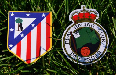 6 Eylül 2019, Madrid, İspanya. İspanyol futbol kulüpleri Real Racing de Santander ve Atletico Madrid 'in amblemleri çimlerin üzerinde.