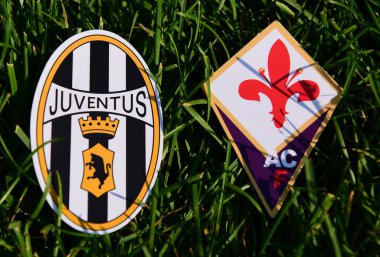 6 Eylül 2019, Torino, İtalya. İtalyan futbol kulüpleri Juventus Torino ve Fiorentina Florence 'ın amblemleri çimlerin yeşil çimlerinde.