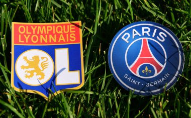 6 Eylül 2019, Paris, Fransa. Fransız futbol kulüpleri Paris Saint-Germain ve Olympique Lyonnais 'in amblemleri çimlerin yeşil çimlerinde.