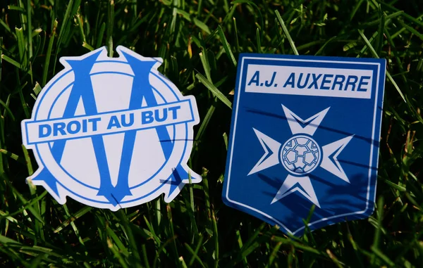 6 Eylül 2019, Paris, Fransa. Fransız futbol kulüpleri Olympique de Marsilya ve Auxerre 'in amblemleri çimlerin yeşil çimlerinde..