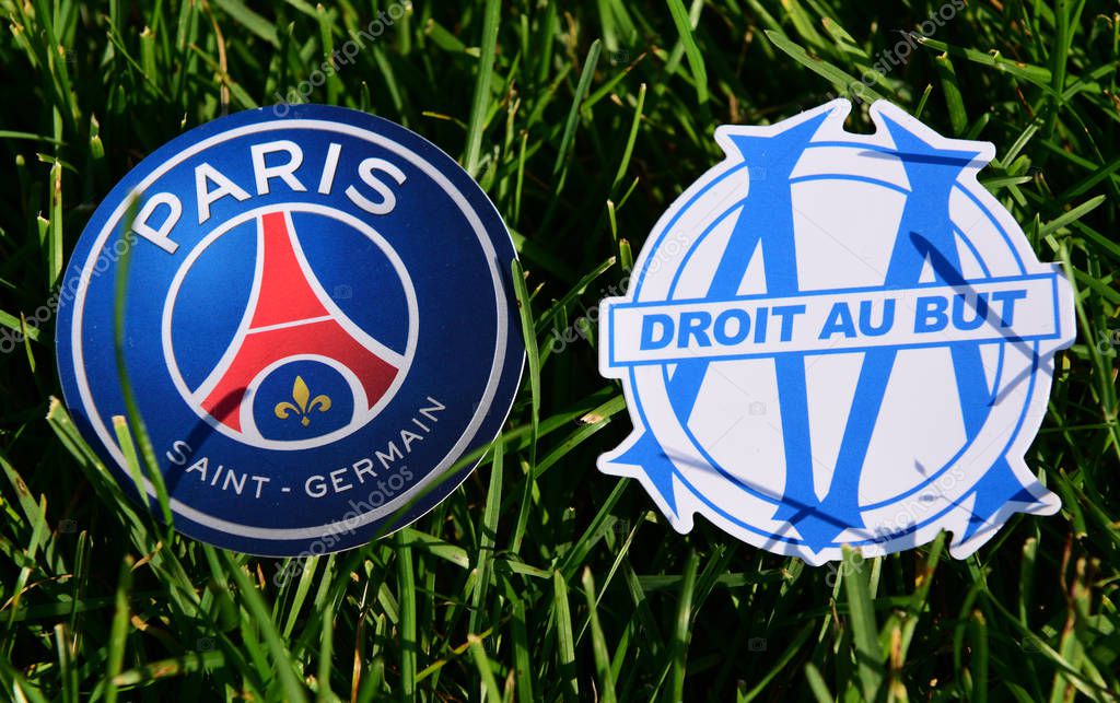 September 6, 2019, Paris, France. Emblems of french football clubs Paris Saint-Germain and Olympique de Marseille on the green grass of the lawn.