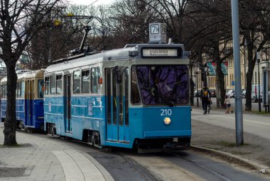 22 Nisan 2018, Stockholm, İsveç. Baharda Stockholm sokaklarından birinde mavi tramvay açık havada.