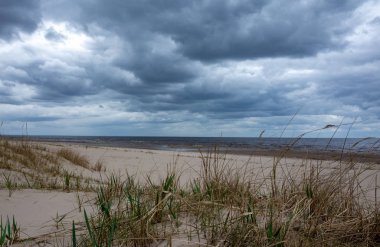 Bulutlar bulutlu bir gökyüzünde Baltık Denizi 'nin kumlu sahillerinde Jurmala' da