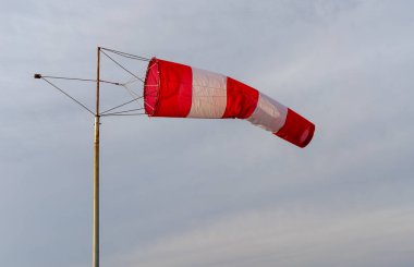 Deniz kıyısındaki rüzgarın yönünü ve yaklaşık hızını belirlemek için tasarlanmış kırmızı-beyaz rüzgar belirteç