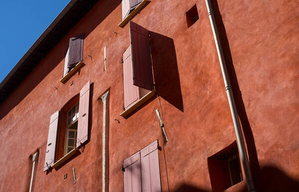 Red shutters on the windows of a house with red walls in the Old City