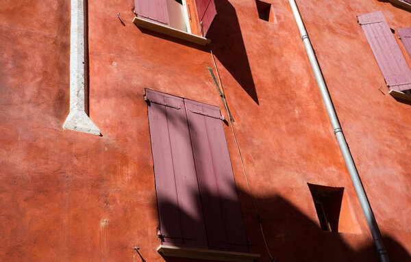 Red shutters on the windows of a house with red walls in the Old City