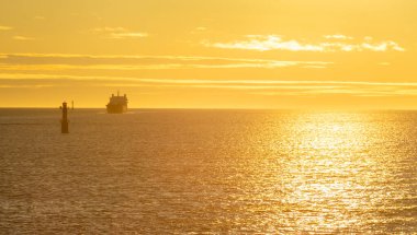 Lighthouse in the strait between the islands of the Stockholm archipelago, lit by the rays of the sun, in the early morning.