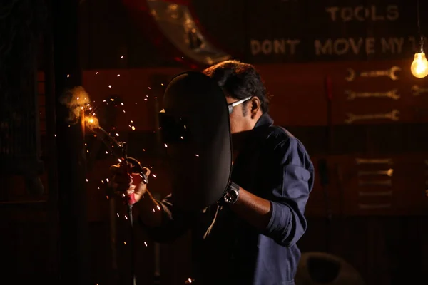 Man welding in shed