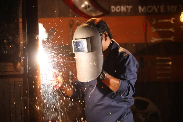Man welding in shed