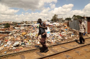İnsanlar Nairobi Kenya Afrika çöp yığınlarının yanında yürüyor