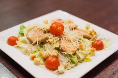 Sezar salata tavuk domates ile dekore edilmiştir.