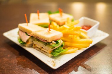 Kızarmış patates ve beyaz tabakta sosu ile Mini sandviç