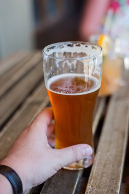 bir adamın elini tutan bir bardak bira portre