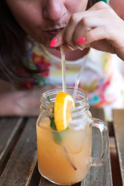 Kız içecekler suyu bir tüp closeup aracılığıyla