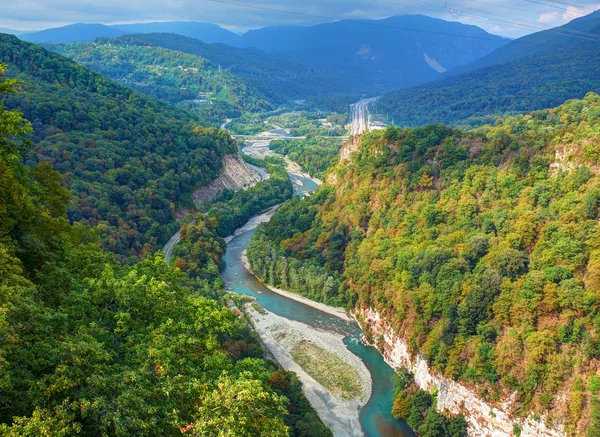 Beautiful view on park hills forest and green mountains, river rafting on yellow boats with tourists. Russia Sochi best holidays vacation tour. Sochi adler SKYPARK metal bridge. National park