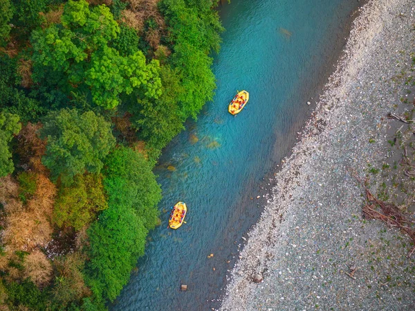 Vista diagonale dall'alto su rafting fluviale su imbarcazioni gialle con turisti sportivi senza caschi. Vacanze rafting a Sochi — Foto Stock