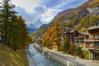 Zermatt, İsviçre, 20 Ekim 2010: Swiss cottage dağ evi tarzı sokak Bachstrasse ve nehir madde Vispa ve Matterhorn ve Alpler Dağı'nda Alplerle görünüm. Klasik Swiss cottage dağ evi