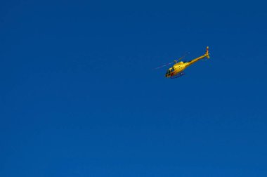 Sarı kırmızı turistik yolcu hiçbir bulutlar ile mavi gökyüzünde uçan bir helikopter. Sarı helikopter helikopter. Güneşli yaz gün Alp Dağları gezi helikopter. Hava bir helikopter