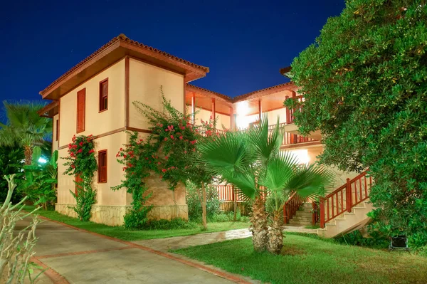 BELEK, TURKEY, SEP. 10, 2010: Vista noturna de verão em moradias de luxo do hotel Paloma Grida Village Spa. Arquitetura de madeira estilo italiano. Férias Turquia férias passeios famosos. Famoso hotel de luxo — Fotografia de Stock