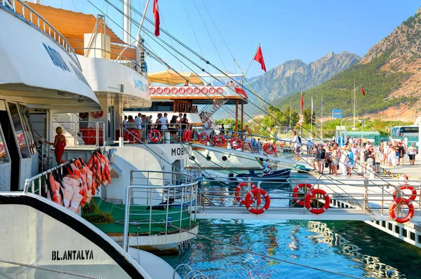 TURKEY, ANTALIA, SEP.10, 2010: View on people tourists boarding on touristic sightseeing white yachts boats to famous waterfall. White boats ships at pier Turkey holidays vacations tours criuise — Stock Photo, Image