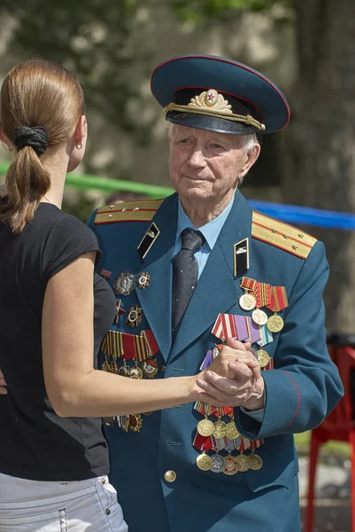 MOSCOW, MAY 9, 2010: Veteran solder in green uniform is dancing with pretty woman on celebration of Great victory 65th anniversary in Gorky Park. USSR victory in Second World War. 9 May Victory day — Stock Photo, Image