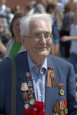 Moskova, 9 Mayıs 2010: Veteran lehim portre madalya yeşil Gorki Park büyük zafer 65 yıldönümü kutlamaları üzerinde üniforma ile. İkinci Dünya Savaşı zaferle SSCB. 9 Mayıs Zafer Bayramı