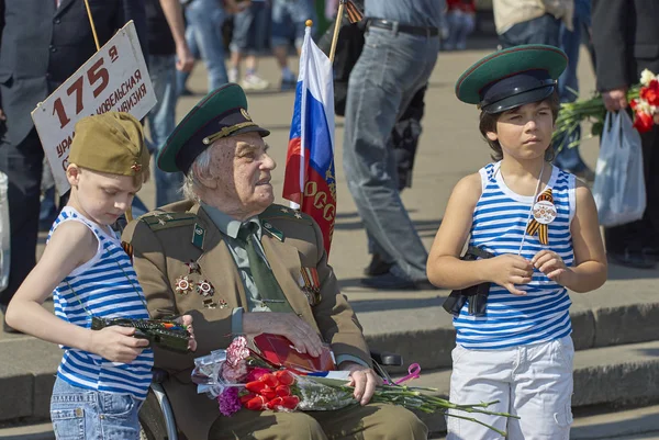 MOSCÚ, 9 DE MAYO DE 2010: Soldado veterano con niños en la celebración de la Gran Victoria 65 aniversario en Gorky Park. Victoria de la URSS en la Segunda Guerra Mundial. 9 de mayo Día de la victoria — Foto de Stock