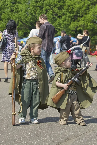 MOSCOW, MAY 9, 2010: Two young boys brothers in green USSR WWII uniform with soviet machine gun, rifle on celebration of Great victory 65th anniversary in Gorky Park garden. USSR  9 May Victory day — Stock Photo, Image