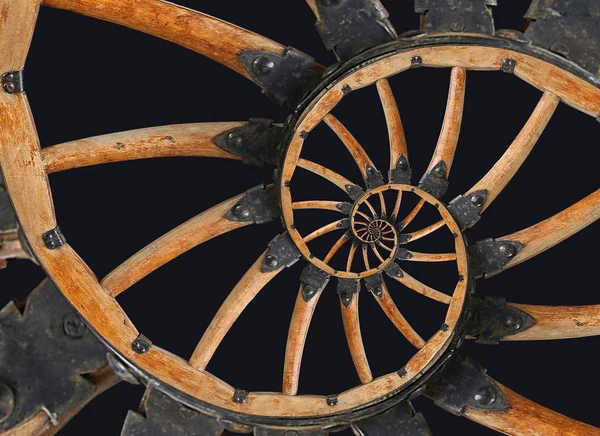 Rueda de cañón de madera espiral abstracta con soportes de metal negro, remaches. Rueda radios de madera fondo fractal. Patrón de rueda de vehículo de caballo dos hilos de fondo fractal espiral aislado en negro — Foto de Stock