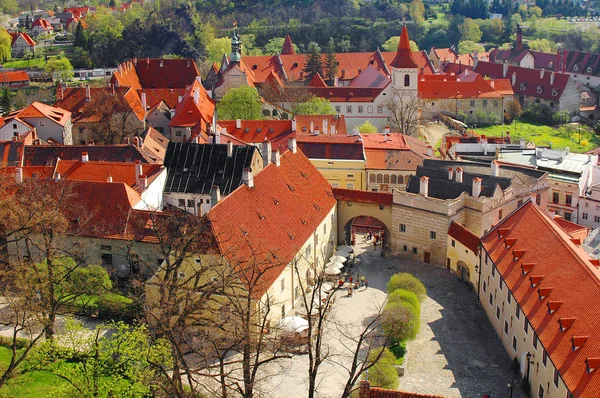 View on old antique buildings orange roofing, castle tower in Czech city Cesky Krumlov. Castle tower on the rock. Wall national Czech painting and ornaments. Famous sightseeing places tours, travel