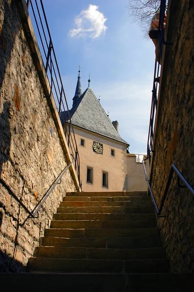 Zobrazit na slavný český hrad Karlštejn v gotickém stylu clock tower, schodiště schodiště architekturu. Tradiční evropské hradní architektury. Perspektivní pohled na věž a zámecké schodiště — Stock fotografie