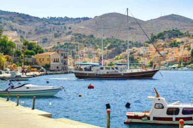 Yunanca Symi Adası liman liman, klasik gemi yat, görünümü ada tepelerde, turist Ege Denizi defne ev sahipliği yapmaktadır. Yunanistan Adaları tatil tatil Rodos Adası turları seyahat. Yunanistan mimarisi