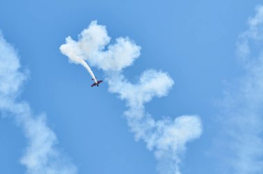 Spor uçak Buhar iz helezon şeklinde görüntüleyin. Mavi gökyüzü arka plan üzerinde beyaz buhar iz parça. Spor uçak akrobasi manevra dublör. Uçak Buhar iz gökyüzünde iplik.