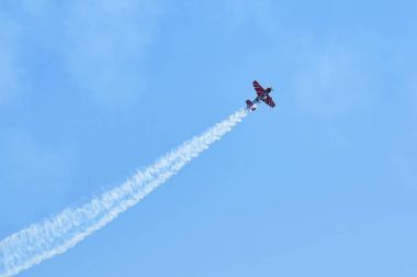 Bir spor uçak akrobasi ekibi buhar parkurları mavi gökyüzü. Uçak beyaz buhar iz parça arka plan. Tek spor uçak akrobasi manevra dublör. Eğri uçak Buhar yollar
