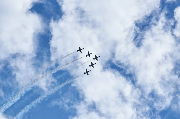 Sport planes aerobatic team vapour trails in blue sky. Plane white vapour trails tracks background. Plane aerobatic maneuver stunt. Stunt planes aerobatic team vapor trails Royalty Free Stock Photos