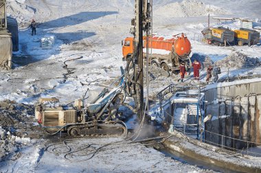 Moskova, 01 Şubat 2018: Kış görünümü üzerinde kirli ağır inşaat ekipman, araç ve işçilerin iş yerinde. Şantiye Delme işlemleri. Pis işleri inşaat alanında. İnşaat makineleri