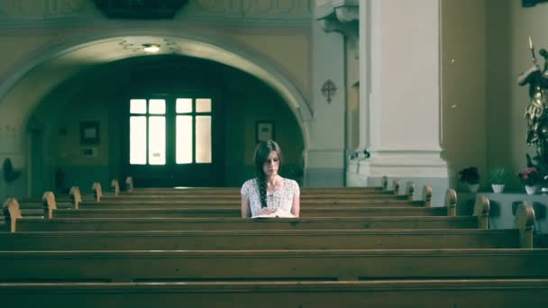 Meisje het lezen van een boek in de kerk. — Stockvideo