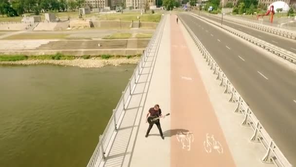 Guitarist, rock musician, street musician on the bridge. Shooting from the air — Stock Video