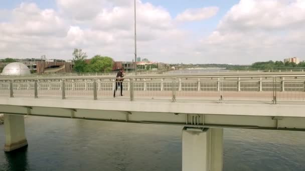 Гитарист, рок-музыкант, уличный музыкант на мосту. Стрельба с воздуха — стоковое видео