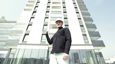 Erkek Oluşturucusu'nda siyah gömlek ve beyaz inşaat kask, önemli ölçüde atar elleri ve güvenle gülümseyen.