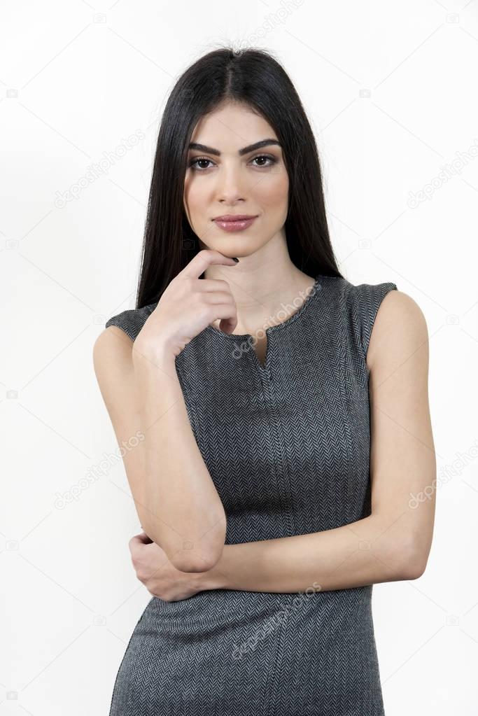 Young business woman standing with hand on chin.