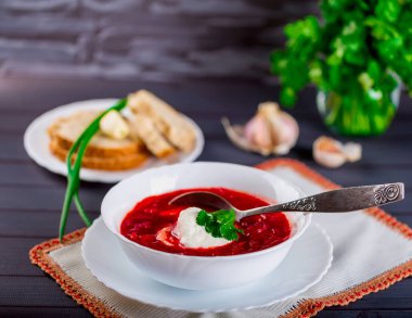 Karanlık masada beyaz tabak içinde Ukrayna pancar çorbası