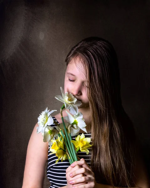 Teen girl Inhale aroma of bouquet of daffodils